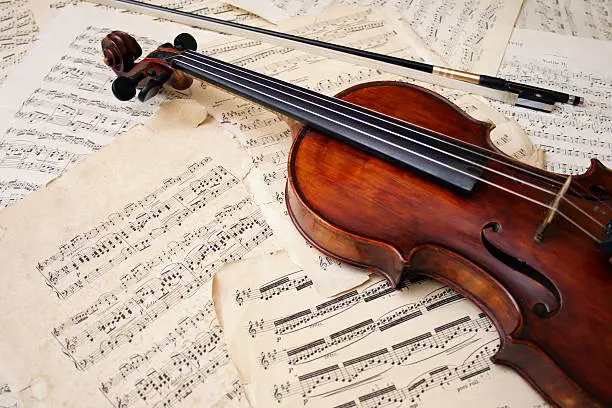 Photo of Violin with bow on sheet music