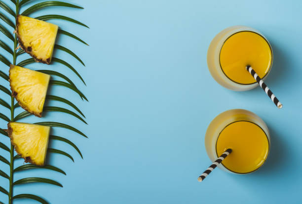 istock Pineapple juice or smoothies and pineapple slices on a blue background 943768358