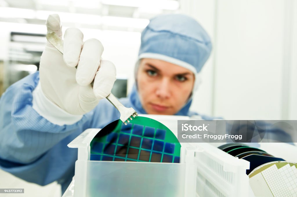 Mujer científico trabajando en la fabricación de la oblea de silicio en sala blanca - Foto de stock de Semiconductor libre de derechos