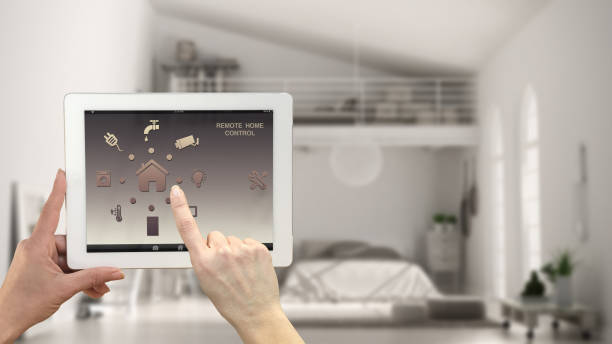 istock Smart remote home control system on a digital tablet. Device with app icons. Blurry interior of modern loft in the background, architecture design 943776774