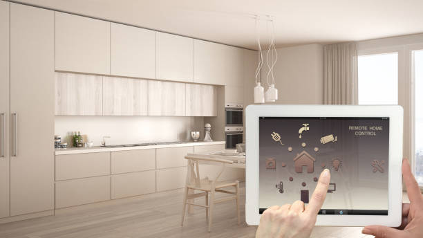 istock Smart remote home control system on a digital tablet. Device with app icons. Interior of classic white and wooden kitchen in the background, architecture design 943776908