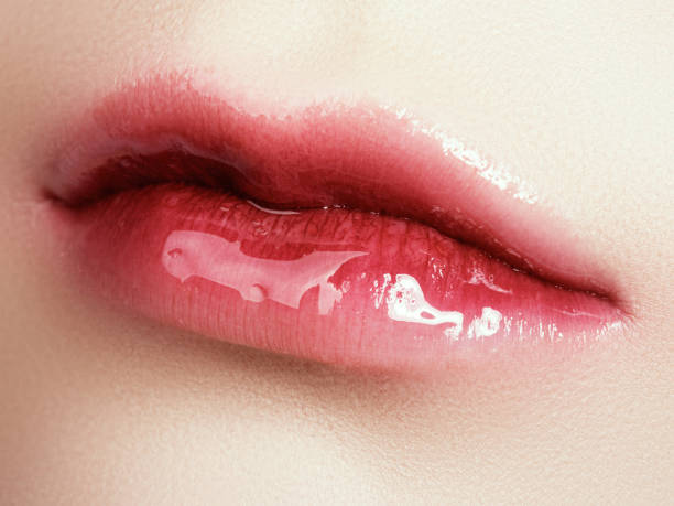 primer planos hermosa mujer los labios con el maquillaje de labios brillante. perfecta para la piel limpia, luz maquillaje labios frescos. macro hermoso spa con brillo de labios rosado tierno. spa y cosmética - gloss de labios fotografías e imágenes de stock