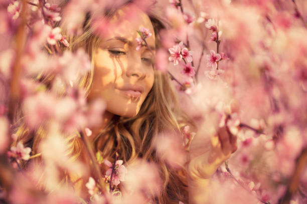 istock Beautiful young woman with cherry blossom at spring 943786254