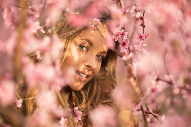 istock Beautiful young woman with cherry blossom at spring 943786260