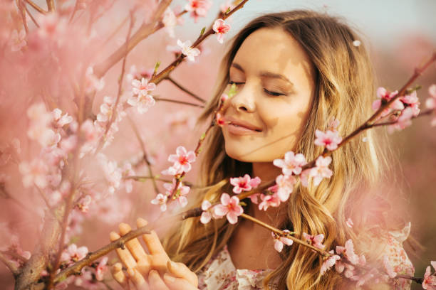istock Beautiful young woman with cherry blossom at spring 943786516