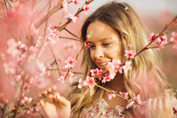 istock Beautiful young woman with cherry blossom at spring 943786660