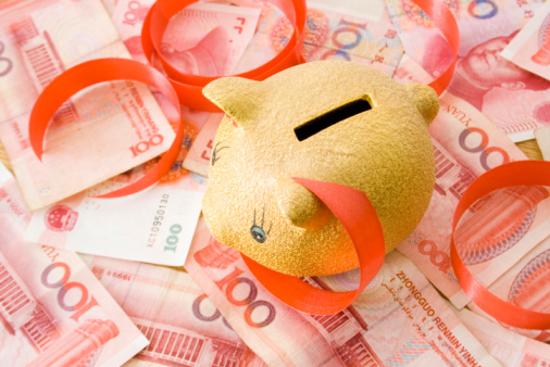 Money bag with chinese yuan symbol and piggy bank with crawling snail