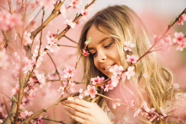 istock Beautiful young woman with cherry blossom at spring 943787496