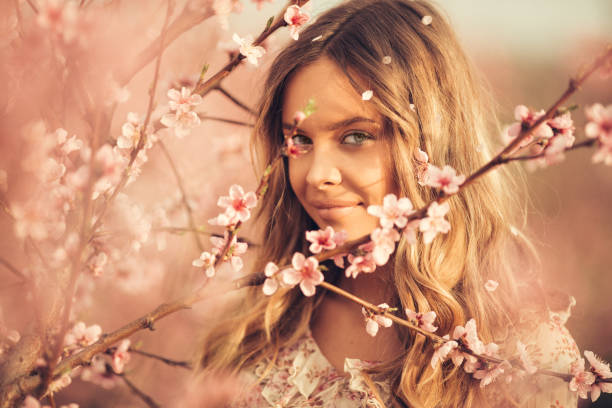 istock Beautiful young woman with cherry blossom at spring 943792086