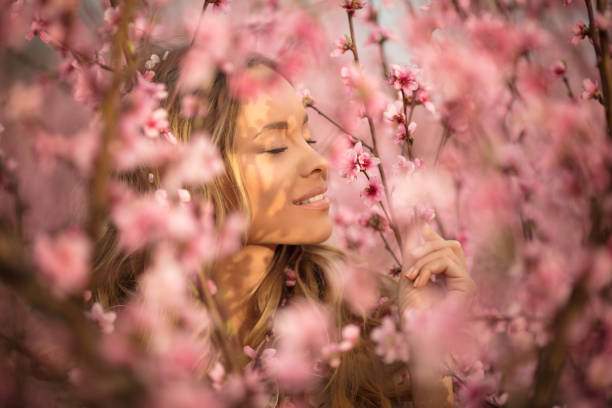 istock Beautiful young woman with cherry blossom at spring 943792104