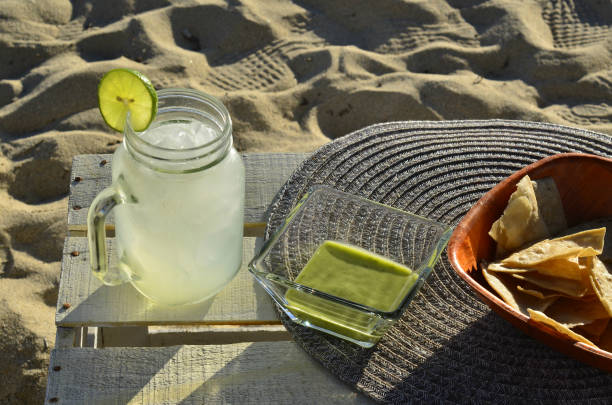 istock lemonade, chips and green salsa at the beach 943792278
