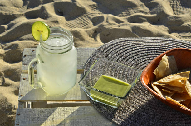 istock lemonade, chips and green salsa at the beach 943792282