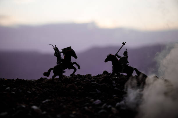 Joust between two knights on horseback. Sunset on background. Selective focus