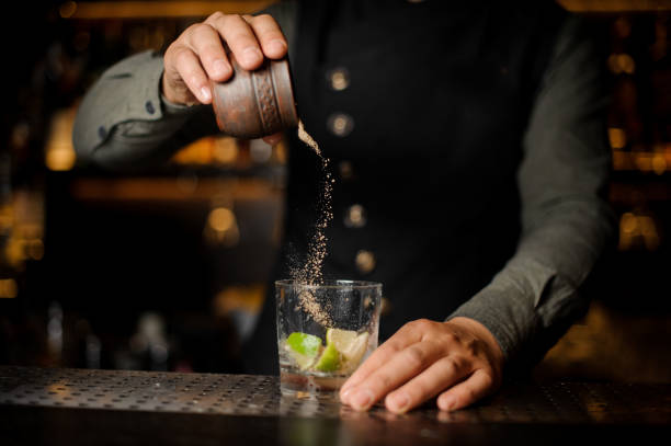 istock Bartender pouring cane sugar into the cocktail glass 943800328