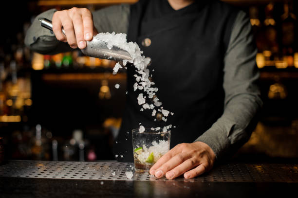 istock Barman puring ice into the cocktail glass 943800356