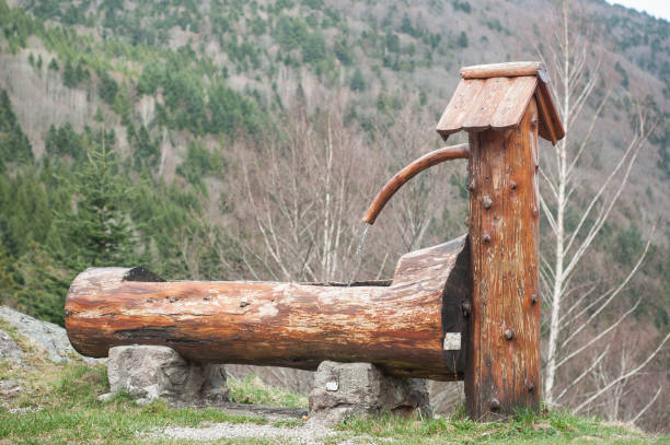 istock typical wooden fountain on moutain landscape background 943800380