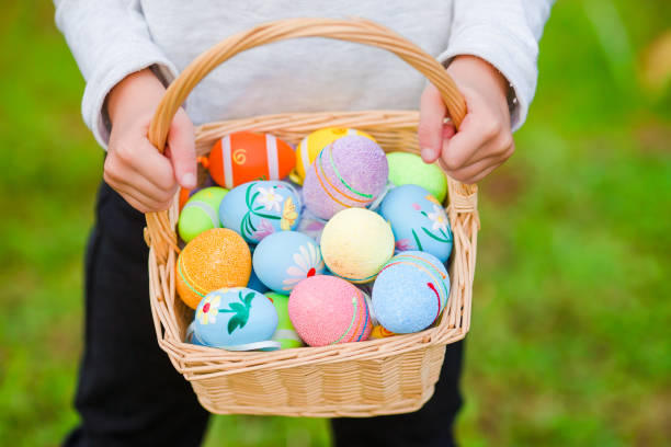 istock Closeup basket full of colorful Easter eggs in kids hands 943801056