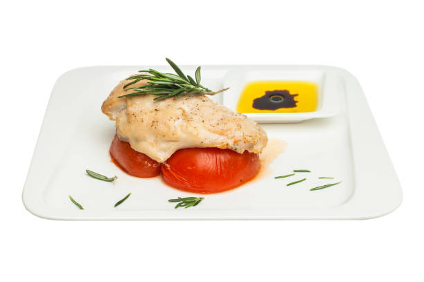 istock Chicken breast with tomato and rosemary herb isolated on white 943804428