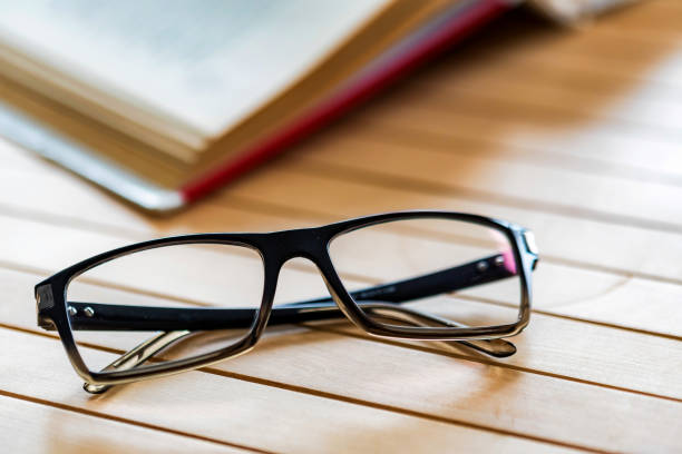 istock Open book and glasses on wooden table close 943804472