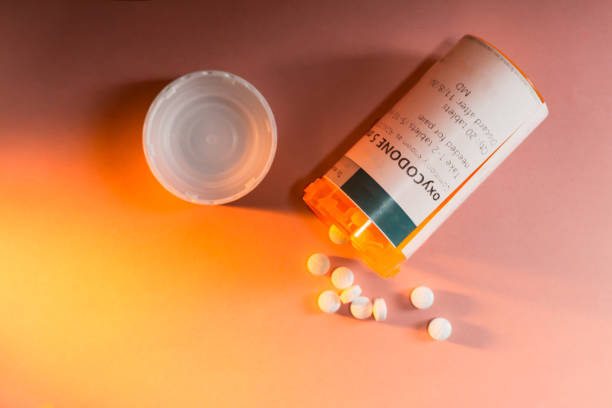 botella de la prescripción de oxicodona con pastillas desbordándose - morfina medicamento fotos fotografías e imágenes de stock