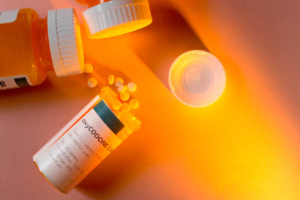 botella de la prescripción de oxicodona con pastillas desbordándose - morfina medicamento fotos fotografías e imágenes de stock