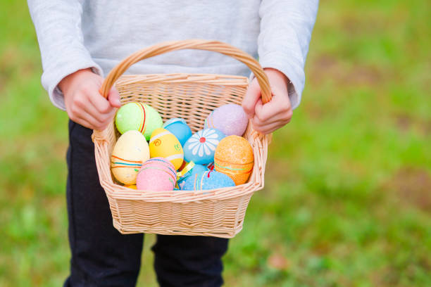 istock Closeup basket with colorful Easter eggs in kids hands 943816022