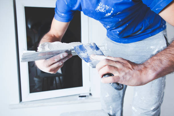 istock scraper and cement filling for house renovation construction in hands 943818910