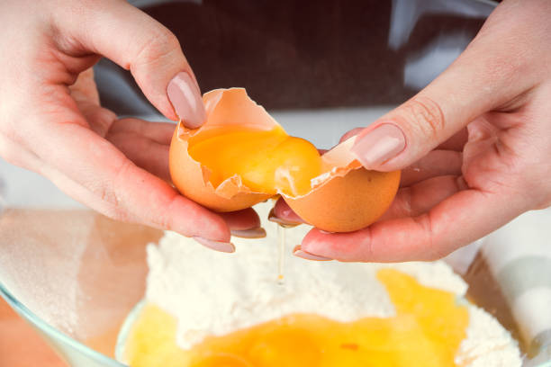 istock Female hands break the egg into a flour close up 943821258