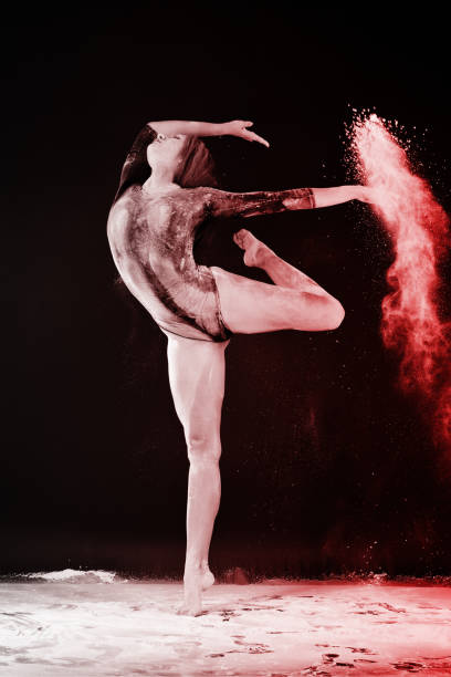 istock Slender blonde dancing in white dust studio shot 943821432