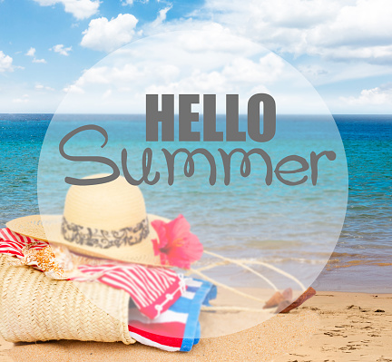 sunbathing accessories on beach in straw bag, summer relaxation and vacations concept with hello summer greeting