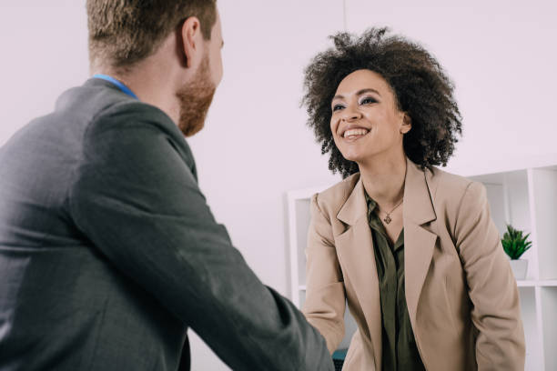 istock Pleasant coworkers shaking hands and smiling 943831884