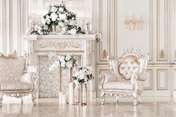 Luxurious vintage interior with fireplace in the aristocratic style. Large Windows and mirrors. Columns and arches, ornament on the glossy floor.