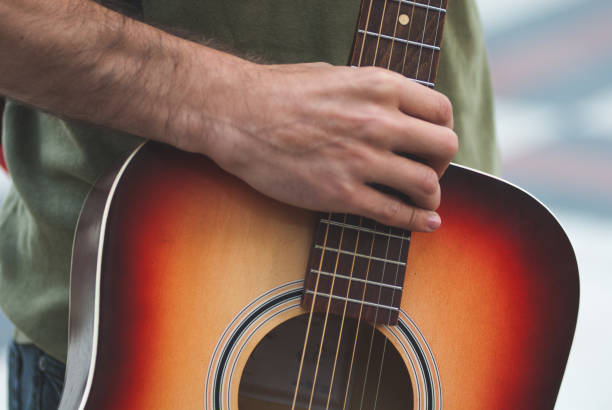 istock man holding a guitar, close-up, musician. 943842138