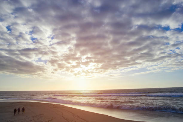 Fishermen in ocean from beach on sunset, Portugal