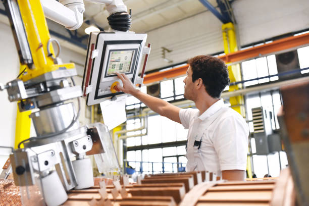 trabalhadores jovens engenharia mecânica operam uma máquina para enrolar o fio de cobre - produção de transformadores em uma fábrica de - transformers - fotografias e filmes do acervo