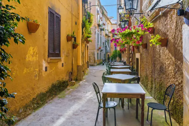 Photo of Cafe tables and chairs outside in old cozy street in the Positano town, Italy