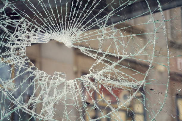 hole in broken shattered security glass, insurance security crime concept - vandalism imagens e fotografias de stock