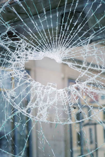 istock Hole in broken shattered security glass, insurance security crime concept 943848656