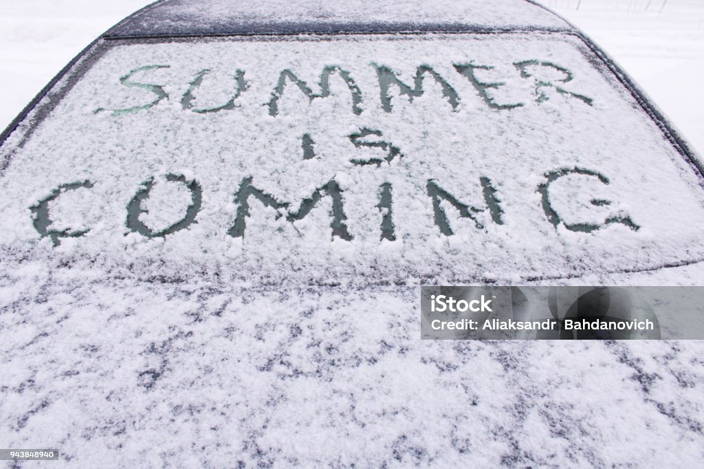 The inscription soon the summer on the frozen glass of the car The inscription soon the summer on the frozen glass of the car . Blizzard Stock Photo