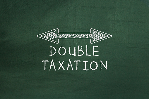 Double arrowed line showing Double taxation concept on chalkboard