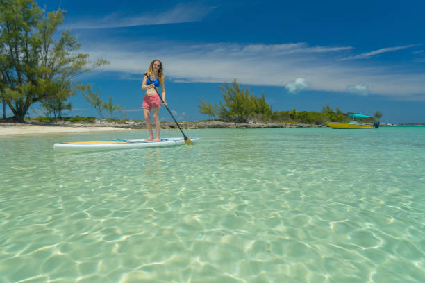 багамские острова бич paddleboarder - eleuthera island стоковые фото и изображения