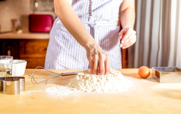 istock Making dough by female hands on wooden table 943855654