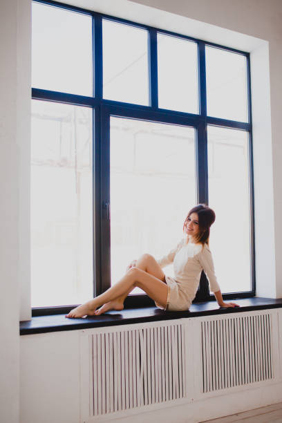istock Tall slender brunette near the window 943856396