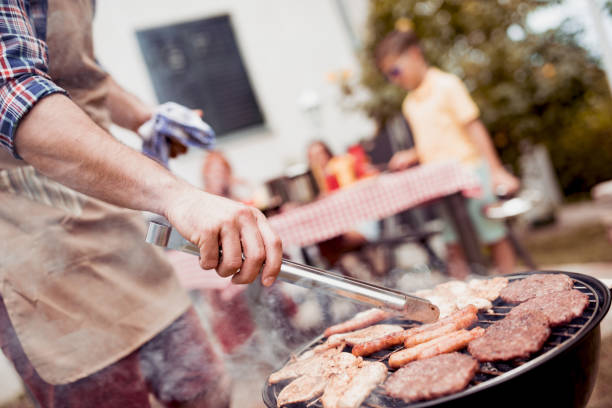 istock Young man grilling meat on barbecue for family dinner 943859194