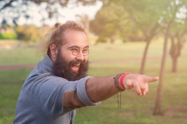 istock the happy bearded man is pointing, showing! 943859294