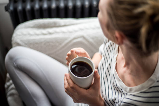 Young woman enjoying coffee and relaxing on a sofa stock photo