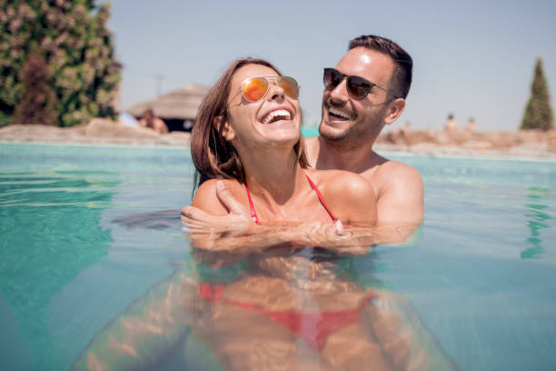 istock Loving happy couple in pool 943863934