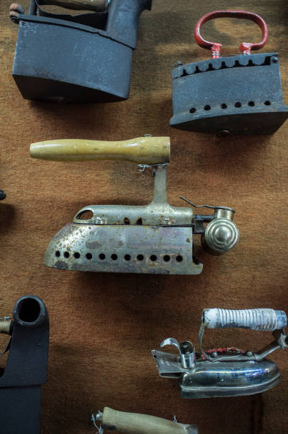 istock Collection of old metal clothes irons displayed on wall 943875398