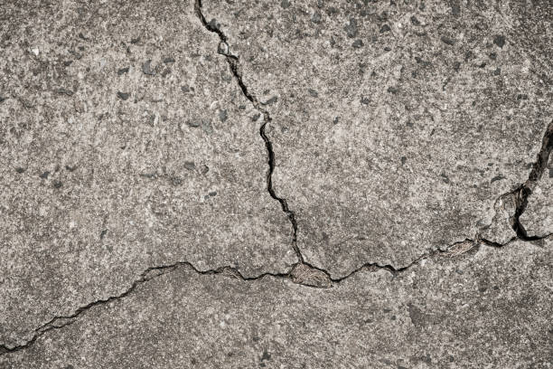 istock cracked concrete floor - crack in wall - broken stone texture 943879054