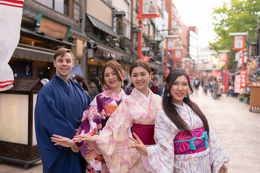 Multi-Ethnic group of people in kimono standing in traditional Japanese town